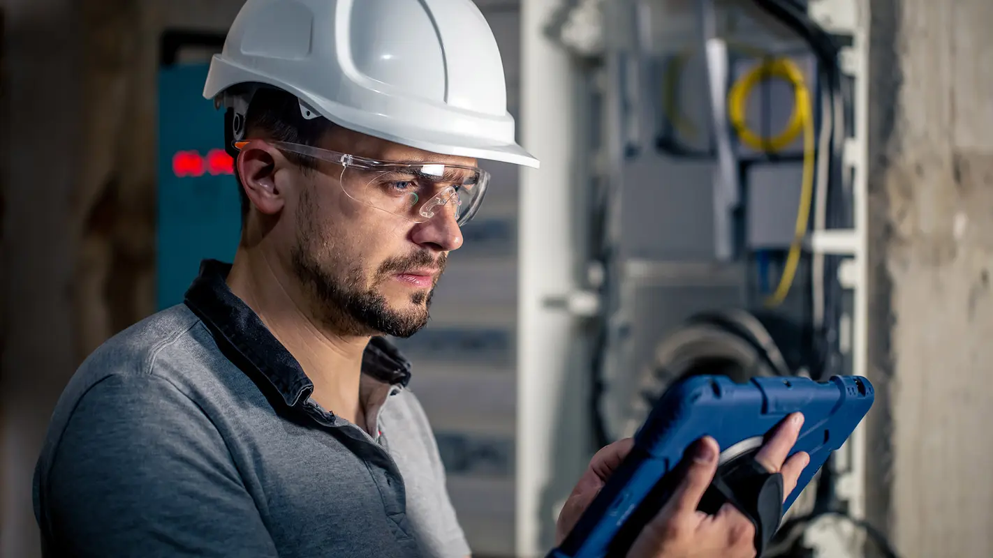 img__0000s_0004_man-electrical-technician-working-switchboard-with-fuses-uses-tablet